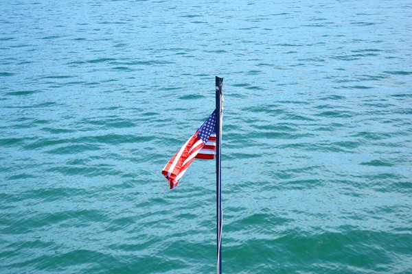 夏の晴れた日のアメリカ合衆国の旗 アメリカの国旗は 水の青と波でボート ポールにかかっています フィルター処理していない 自然な照明 — ストック写真