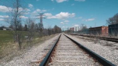 Trenin dibindeki demiryolu manzarası. Tren raylarındaki tren yolculuklarının taklidi. Trenin ön tarafından bak. Tren yolu rayları üzerinde süzülen havadaki yavaşlama..