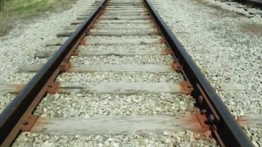Trenin dibindeki demiryolu manzarası. Tren raylarındaki tren yolculuklarının taklidi. Trenin ön tarafından bak. Tren yolu rayları üzerinde süzülen havadaki yavaşlama..
