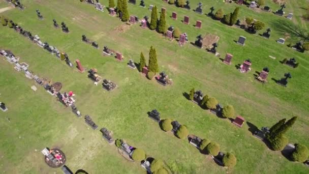 Hover over modern American city cemetery. Many grave stone and stone crosses at city cemetery. Sunny Spring day. Aerial view at burial ground tombs from above. — Vídeo de stock