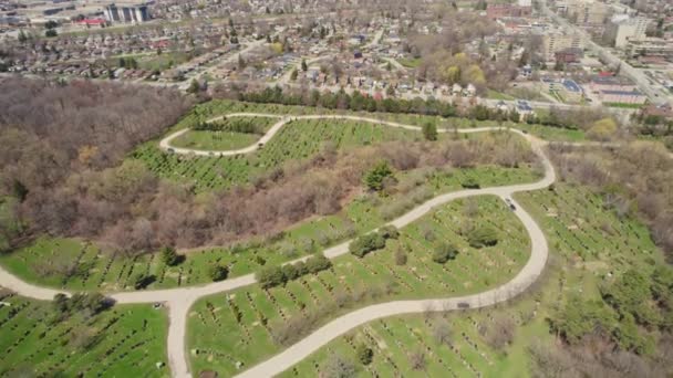 Hover over modern American city cemetery. Many grave stone and stone crosses at city cemetery. Sunny Spring day. Aerial view at burial ground tombs from above. — 비디오