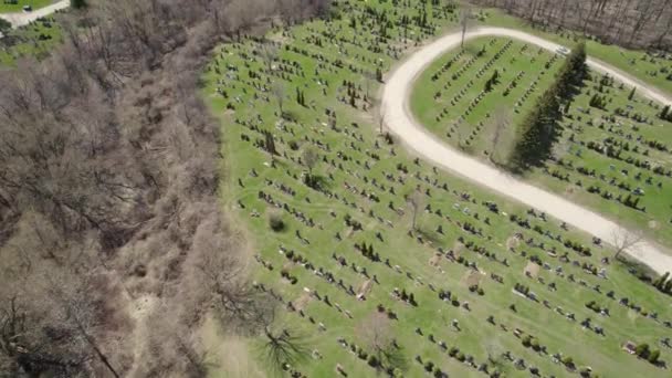 Zweef boven de moderne Amerikaanse begraafplaats. Veel grafstenen en stenen kruisen op de begraafplaats van de stad. Zonnige lentedag. Uitzicht vanuit de lucht op graftombes van bovenaf. — Stockvideo