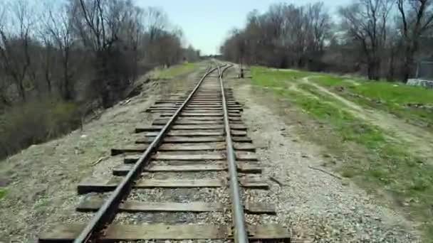 Svävar lågt över ett järnvägsspår, tågperspektivvy. Snabb förflyttning över järnvägsspåren i stadens urbana område. Utsikt framifrån på tåget. — Stockvideo