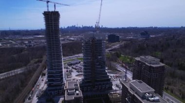 Yeni yapılar inşaatı alanına yakın ve çevresindeki hava uçuşları. Gökdelenlerin ve yüksek binaların modern mimarisi. Gayrimenkul kavramı. Boş çalışma alanı, vinçler ve ağır makineler