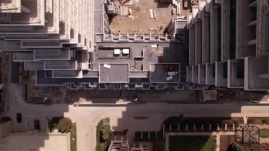 Boş inşaat sahasına, vinçlere ve makinelere, şehir merkezindeki araba trafiğine bakın. Havadan görünüşlü. Yeni konut inşaatı beton çerçeveli. Kentsel çok katlı apartman.