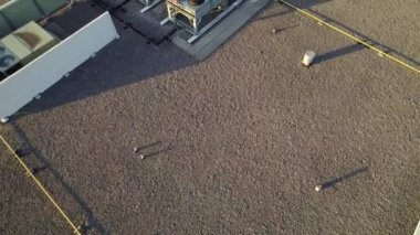 Aerial top view footage of AC exhaust vents of industrial air conditioning and ventilation at roof of grocery store at hot summer day.