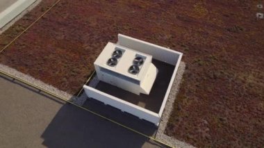 Aerial top view footage of AC exhaust vents of industrial air conditioning and ventilation at roof of grocery store at hot summer day.