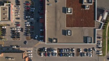 Aerial geometric top view of the grocery food store plaza, supermarket or shopping mall parking lot with lots of cars moving in and out. Time lapse or hyper lapse.