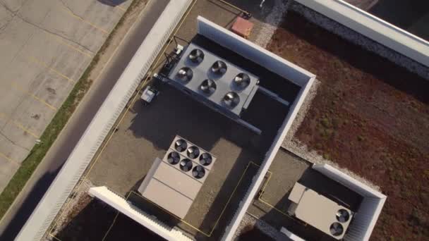 Heating, ventilation and air conditioning systems aerial top view footage on the roof. Exhaust vents of AC at roof of housing or grocery store at hot summer day and golden hour. — Stok video