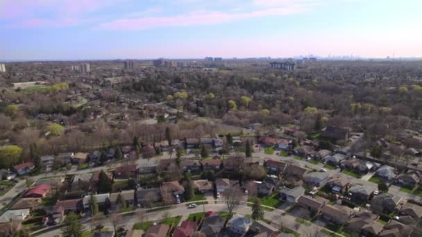 Shot of town in America. Homes in quiet sleep residential housing area. Aerial cinematic bird view of North American city. One level houses in Canada suburbs during Golden hour sunset. — Stock video