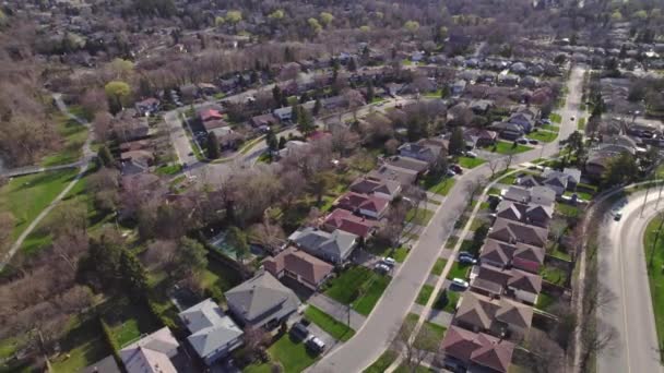 Shot of town in America. Homes in quiet sleep residential housing area. Aerial cinematic bird view of North American city. One level houses in Canada suburbs during Golden hour sunset. — Video