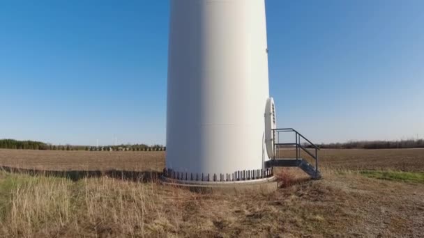 Tiro de la granja de la central eólica desde abajo. Ingeniería ambiental y energías renovables. Vista panorámica de la turbina de molinos de viento con cielo azul por la noche. — Vídeo de stock