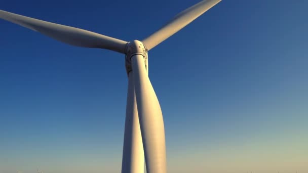 Aerial close up shot of wind mills turbine rotating by the wind and generating renewable green energy. Closeup of a wind turbine during golden hour sunset. Energy alternative and environment ecology. — Stock Video