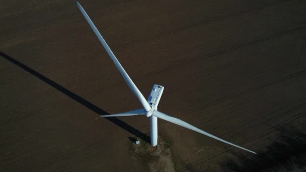 Widok z lotu ptaka potężnej turbiny wiatrowej do produkcji energii z góry o złotej godzinie. Turbiny wiatrowe wytwarzające czystą zrównoważoną energię z góry na dół. Farma wiatraków lub turbin wiatrowych. — Wideo stockowe