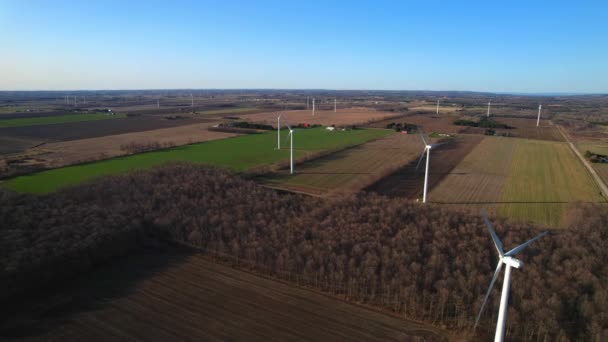 Shot of landscape with wind turbines power station farms on background. Environmental engineering and renewable energy. Scenic aerial view of windmills turbines at golden hour sunset evening. — Stock videók