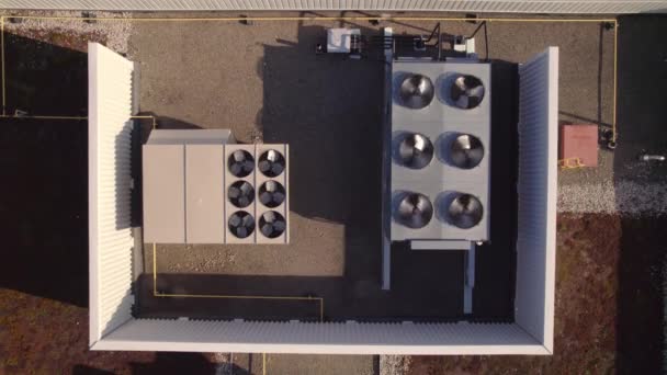 Aerial top view footage of AC exhaust vents of industrial air conditioning and ventilation at roof of grocery store at hot summer day. — Stok video