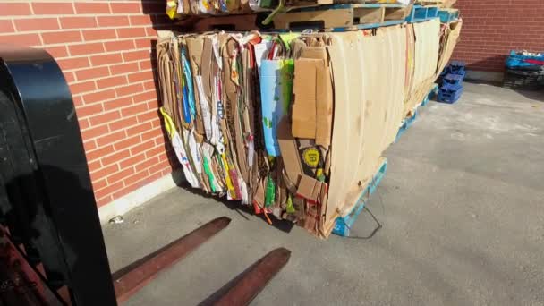 Toronto, Ontario, Canada - April 29, 2022 View behind the grocery store, some paper press machine piles of paper and cardboard with forklift ready for recycling. Garbage dumps of cardboard boxes. — Stockvideo