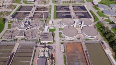 Modern urban wastewater treatment plant. Water purification plant, automatic process of removing chemicals, solids and gases from contaminated water. Water cleaning facility outdoors. Aerial view.
