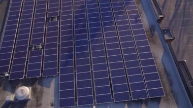 Solar power station panels on the school roof building at golden hour. Green energy at hazy sunset. Set of solar panels plants at college sealing in the evening.