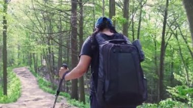 Yaz gezisi ya da tatil sırasında ormanda yürüyüş yapan bir kadın. Serüvenler için açık havada zaman ve boş zaman yolculuğu. Sırt çantalı, sırıklı ya da ormanda yürüyüş yapan aktif bir kadın..