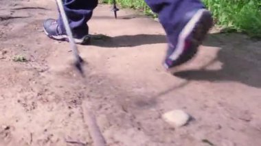 Spor ayakkabılı yürüyüşçü ayaklarını az görüyorum. Direkli ya da bastonlu genç adımlar. Yazın patikada yürüyüş yapmak. Güneşli bir günde vahşi doğada yürür. Aktif kişi ormana tırmanır ya da yürüyüşe çıkar..