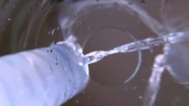 Bir bardak su. Sürahi ya da kavanozdan bardağa saf içme suyu döküldü. Aşağıdan yavaş çekim görüntüsü. Sürahiden şeffaf cama temiz su dökülüyor. Camın dibinden vurulmuş. Seçici odak.
