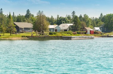 Kanada, Ontario, Huron Gölü 'ndeki Pike Bay boyunca tipik yazlık evler. Mevsimlik tatil kirası ve boş zaman için kulübeler. Turizm beldesi.  
