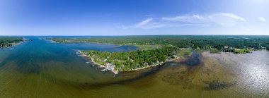 Göl manzaralı kulübeler ve sık ormandaki yazlık kulübeler. Balıkçı evleri, kiralık evler ve yaz pikniği için güzel doğal bir manzara. Huron Gölü. 