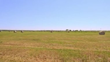 Aerial view of hay bales on the green field and beautiful rural landscape of America. Haystack harvesting dry grass for agriculture and animal food.