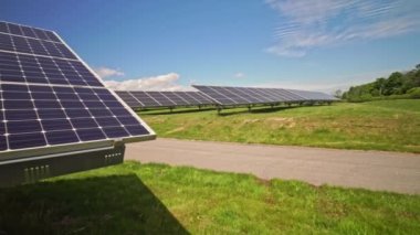 Close up of modern photovoltaic solar panels to charge battery. Rows of sustainable energy solar panels set up on the farmland. Green energy and environment ecology concept.