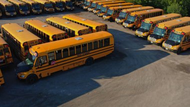 Toronto, Ontario, Canada - September 1, 2022: View on parked American buses in Canada waiting for the educational season. Yellow school buses in parking at golden hour. 