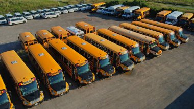 Toronto, Ontario, Canada - September 1, 2022: View on parked American buses in Canada waiting for the educational season. Yellow school buses in parking at golden hour. 