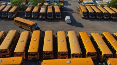 Toronto, Ontario, Canada - September 1, 2022: School bus vehicles ready for school educational season. Top view of parking yard with yellow trucks and evening sky, ready to pick up and drop off kids.