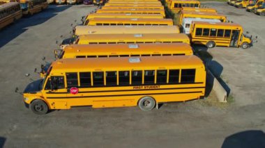 Toronto, Ontario, Canada - September 1, 2022: School bus vehicles ready for school educational season. Top view of parking yard with yellow trucks and evening sky, ready to pick up and drop off kids.
