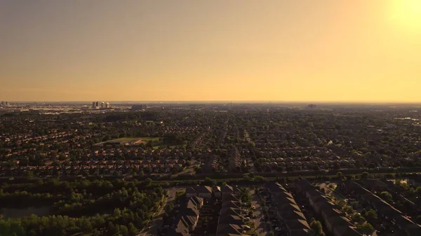 Aerial view of American suburban neighbourhood. Residential single American family houses. North America suburb streets. Established Real estate at golden hour sunset with long shadows.