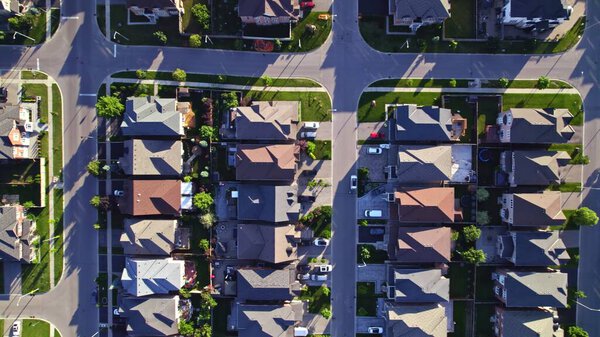 Aerial view of middle class residential houses at summer evening. American neighbourhood suburb. Residential houses and homes build in strong pattern to each other. Real estate.