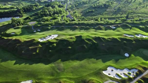 ゴルフ場の空中ビュー ゴルフクラブの上に緑のショット 長い影を持つ黄金の時間夏の夕日 — ストック動画