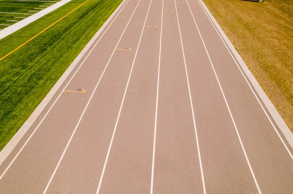 运动员或运动员跑步者对在比赛中跑步的看法 跑车轨道和有白漆标记的赛道的Pov 在跑道上跑步 — 图库照片
