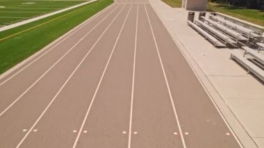 Açık hava spor stadyumundaki koşu pisti manzarasının üzerinde. Atletizm stadyumu ve koşu pisti boyunca yarışan atlet POV. Rekabet sporları ve şampiyon sıkı çalışma.