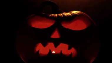 Cadılar Bayramı 'nız kutlu olsun. Cadılar Bayramı balkabağı parlayan yüzü, seçici odaklanma. Karanlık arka planda parıldayan korkunç Jack O Lantern ruh iblisi. Geleneksel Cadılar Bayramı sembolü.