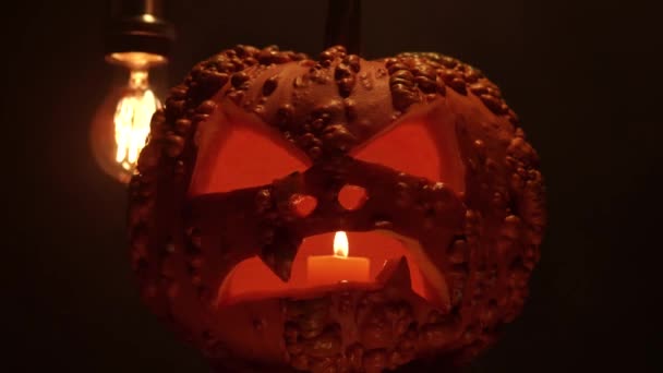 暗い夜の背景にキャンドルライトと彫刻ハロウィンカボチャ ハロウィンカボチャの怖い笑顔とパーティーのお祝いの目 伝統的なハロウィーンのホラーシンボル — ストック動画