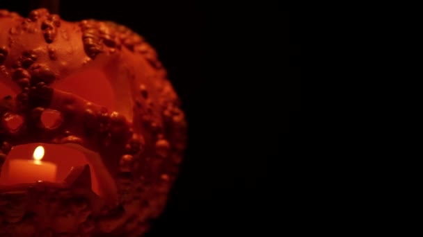 怖い顔とワープを持つハロウィンカボチャ ろうそくの光と暗闇の中で輝くジャックOランタンカボチャを祝う — ストック動画