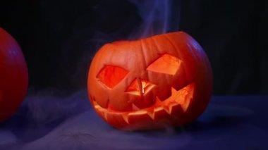 İki balkabağı dumanın içinde bir mum, arkasında karanlık bir arka plan, her yerde bir sis var, Cadılar Bayramı konsepti, korkunç sahneler, korku sahneleri.