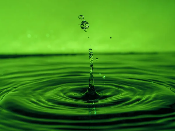 Una Gota Verde Gotea Agua Crea Salpicaduras Varias Formas Debido — Foto de Stock