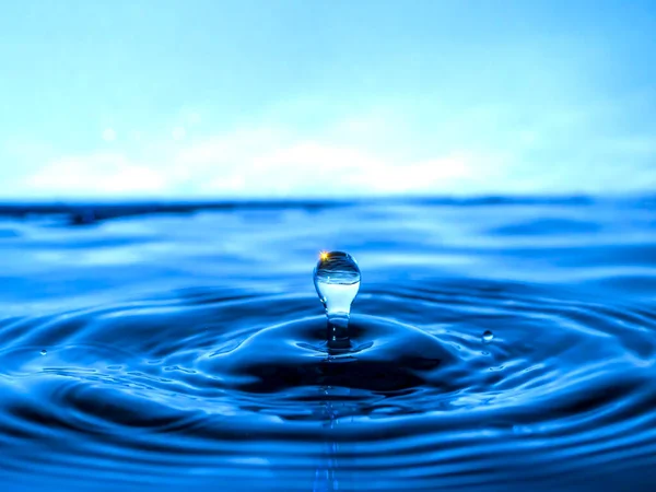 Ein Blauer Tropfen Tropft Ins Wasser Und Erzeugt Spritzer Verschiedenen — Stockfoto