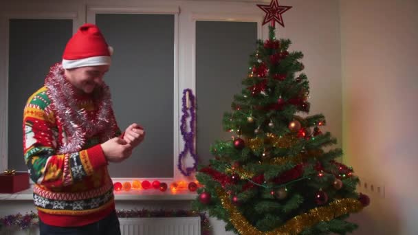 Young Man Celebrating Holiday Clapping Clapperboard Wearing Christmas Sweater Hat — Stock Video