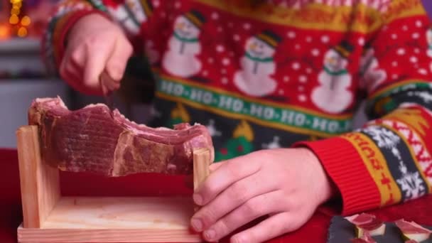 Mladý Muž Sedí Slavnostního Stolu Krájí Jamon Sobě Vánoční Svetr — Stock video