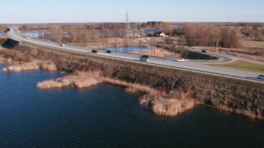 Lielupe Nehri üzerinde çatallı bir hava köprüsü, üzerinde arabaların hareket ettiği bir köprü, bir trafik otoyolu konsepti.