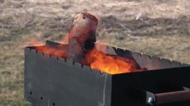 Ahşap odun odunları siyah bir brazier içinde alev alır ve sonra barbekü, şiş kebap, kebap ve diğer et yemekleri pişirir.