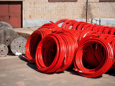 Çok sayıda kırmızı pvc boru büyük rulo içine bükülmüş yalan, onarım konsepti, boru yenileme, depo, kıtlık